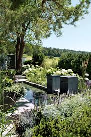 Ein Garten Mit Viel Wasser Ein Brunnen Mit Zwei Kubischen Speiern Und Ein Schwimmteich Auf Der Unteren Ebene Des Ga Gartengestaltung Wasserspiel Garten Garten