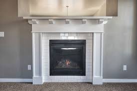 Black And White Tile Fireplace Surround Cozy Up To This Fireplace Surrounded With White Subway Tile And Beautiful Craftsman Style Mantel Subway Tile Fireplace Fireplace Tile Slate Fireplace Surround