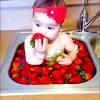 / baby taking bath in kitchen sink. 1