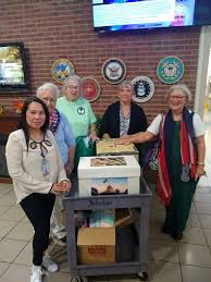 Debra Barlow Hardy showing a t- shirt quilt she made for her grandson at  the October council meeting and a group of mhv at the State Veterans home  presenting donations from the