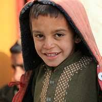 US Marine Corps (USMC) STAFF Sergeant (SSGT) Jonathan C. Knauth (center),  Combat Camera CHIEF, attached to Regimental Combat Team Seven (RCT-7),  poses form a group photograph with a group of Iraqi men