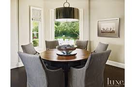 A Round Table Encircled By Lee Industries Chairs Forms A Casual Dining Area Beneath A Art Dining Room Contemporary Dining Room Inspiration Dining Room Lighting