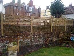 Whether you want a climbing rose trellis or a clematis trellis to adorn your garden, we have designs to enhance your space get one today and have the perfect place to start a vertical garden for climbing plants to grow. Wooden Privacy Trellis Attached To Top Of Brick Wall Brick Garden Garden Trellis Fence Backyard Trellis