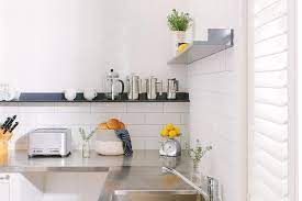 Do you want stainless steel cabinets for your home? White Kitchen With Stainless Steel Countertops And Black Shelf Transitional Kitchen