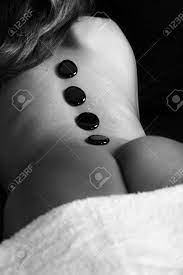 A Beautiful Young Indian Woman Enjoying A Hot Stone Massage And Against A  Dark Background. Generous Accommodation For Copy Space. Concept Image For  Spa, Healthy Lifestyles Etc. Stock Photo, Picture and Royalty