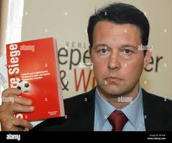 Canadian journalist Declan Hill poses with his latest book 'Sichere Siege.  Fussball und organisiertes Verbrechen oder wie Fußballspiele manipuliert  werden' (Canadian title: 'The Fix: Soccer and Organized Crime') at  publishing house Kiepenheuer