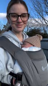 Cómodamente de paseo con su bebé en su Ergobaby Embrace 💞, @nicole_adams16
