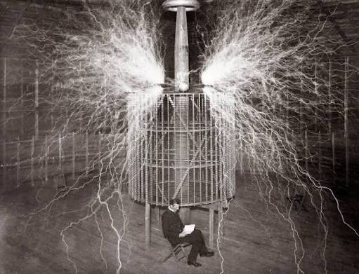 Nikola Tesla assis dans son laboratoire dans le Colorado Springs avec son "  Magnifying Transmitter " de anonyme - Photographie d'art