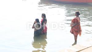 Hindu women pilgrims take bath in the water Holy river Ganges. Varanasi,  India