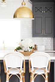 There's no reason not to bring old world elegance back into the light. Black Kitchen Island With White Countertops Gold Pendant Lights And White And Ratan Barstools Salt Box Co Home Decor Black Kitchen Island Home Decor Kitchen