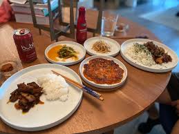 Politeness is very important in korean culture, and there is a lot of emphasis placed on sharing meals and drinks. Homemade Korean Dinner Of Spicy Stir Fry Pork Belly Kimchi Pancake Scallion Salad Seasoned Soybean Sprouts And Ssamjang Food
