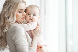 Young Mother Taking Care Of Her Little Baby Girl Beautiful Mom And Her Daughter Indoors In The Bedroom Loving Family Attractive Mum Holding Her Child Little Baby Girl Young Mother Holding