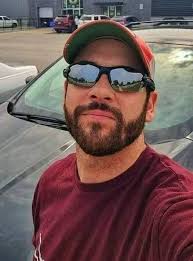 A man steps in to help a woman at a gas station