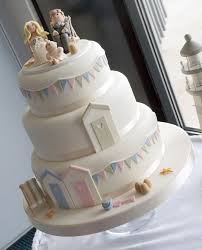 Beach Themed Three Tier Wedding Cake With Pastel Colours Beach Huts And Deckchairs Cute Seaside Wedding Cake Beach Theme Wedding Cakes Nautical Wedding Cakes