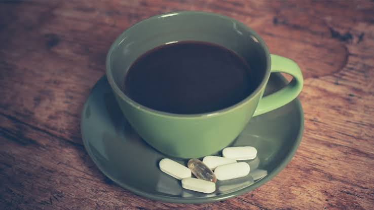 Cup of coffee next to medication bottle with warning symbol - drug interaction risks