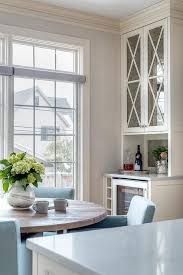 A Round Gray Wood Dining Table Is Surrounded By Powder Blue Dining Chairs Placed In A Nook Beside A Small Bar Home Renovation House Interior Home