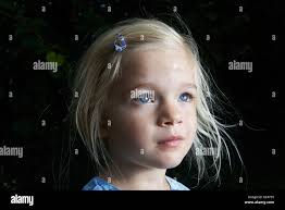 Porträt des Kindes etwas blondes Mädchen im Garten, draußen im Sommergarten  allein Stockfotografie