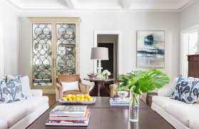 Green maze pattern pillows on a white slipcovered sofa against a wall styled with a green and white wall art gallery. White Sofas With Blue Ikat Pillows Transitional Living Room