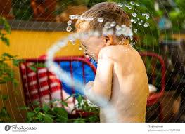 Junge wird auf der Terrasse mit Wasser bespritzt und dreht sich weg - ein  lizenzfreies Stock Foto von Photocase