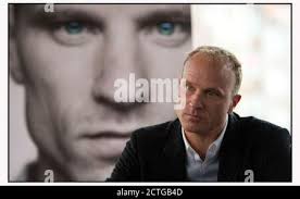 DENNIS BERGKAMP AD AMSTERDAM AL LANCIO DELLA SUA BIOGRAFIA, DI FRONTE AD  UNA FOTO DELLA COPERTINA DEL SUO LIBRO. IMMAGINE: © MARK PAIN