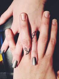 Black ring bands, replacing traditional wedding rings, are portrayed on the wearers' ring fingers in this tattoo set. 225 Wedding Ring Tattoos For 2021