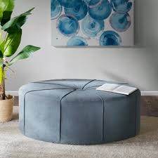 Light Blue Ottoman Wayfair A casual color palette that includes a cream colored couch, blue and brown pillows, and a blue ottoman coffee table.
