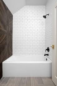 A Drop In Bathtub Is Accented With White Subway Tiles Finished With Black Grout Lined With A Mat White Subway Tile Bathroom White Subway Tiles Wood Tile Shower