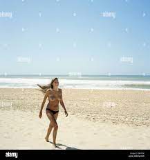 Topless woman walking on empty beach Stock Photo - Alamy
