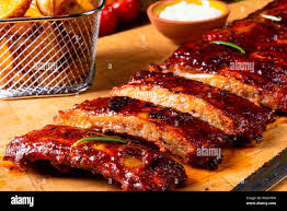 Costillas A La Barbacoa En La Plancha Con Ensalada Verde Y Salsa Blanca Fotografia De Stock Alamy