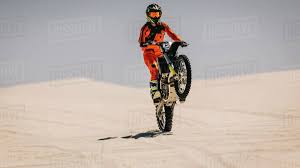 10 hour bike prep + wiring lights on a dirt bike. Professional Dirt Bike Rider Doing Stunts On The Desert Racer Doing Wheelie On Motocross Bike Stock Photo Dissolve