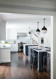 Dual Kitchen Islands In A Dark Charcoal Gray Finish Illuminated By Hicks Pendants Fitted With Kartell Ghost Count Modern Bar Stools Bar Stools Clear Bar Stools