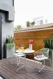 This Contemporary Outdoor Deck Features Modern White Metal Chairs With A White Metal Cafe Table On A B Metal Outdoor Chairs Outdoor Chairs Contemporary Outdoor