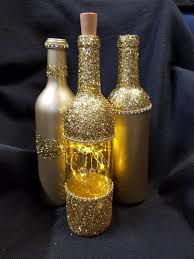 A Set Of 3 Upcycled Wine Bottles 2 Spray Painted A Warm Gold Metallic With Gold Glitter Accents And Go Bottles Decoration Glitter Wine Bottles Wine Bottle Diy