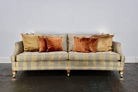 A chair with an ivory slipcover sits underneath a blue and white print poster in a frame. Huge Sublime Duresta Hornblower 3 Seat Sofa In Gold Blue Striped Fabric Lord Browns