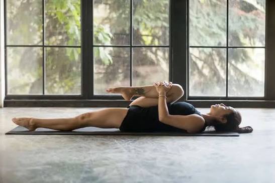 Nằm ngửa gối đầu gối lên ngực, giảm áp lực lên rễ thần kinh