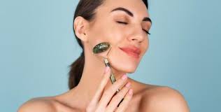 woman using jade roller on jawline for lymphatic massage