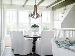 Beach Style Dining Room With Round Dining Table And White Slipcovered Chairs Cottage Dining Room