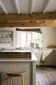 Reclaimed wood beams accentuate the vaulted ceiling and pop against the snowy cabinets and subway tile below. Rustic English Country Kitchen Design Inspiration Hello Lovely