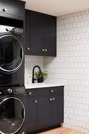 A few manufacturers have combined washers and dryers into a single machine that both washes and dries clothes. Black And White Laundry Room With Stacked Black Front Load Washer And Dryer Modern Laundry Room