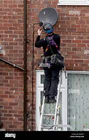 A Sky Television Engineer Installs A Satellite Dish At An Address In  Liverpool Stock Photo - Alamy