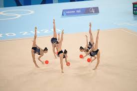 Female athletes perform expressive and acrobatic moves with the aid of handheld apparatus — a hoop, ball, pair of clubs and ribbon. 0tawry7gt X8nm