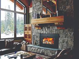 Outdoor sitting area with chairs, round table, fireplace with screen and stone design and seating area next to the pool. Less Money Goes Up In Smoke With These Fireplaces