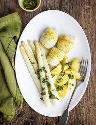 Stendere una fettina di salmone affumicato su ogni filetto di sogliola (tenendo la pelle di quest'ultima all'esterno), poi arrotolarli. Turbanti Di Sogliola Con Asparagi Bianchi E Patate Miele