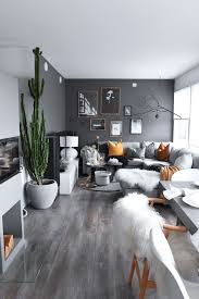 There are a fireplace and a tv on top of it as well. Dark Grey Wall Living Room With Indoor Plants And Orange Details Energizing And Cozy Interior Black Walls Living Room Living Room Grey Dark Grey Living Room
