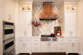 These grey kitchen cabinets have an elegant feel due to the feet on the sink cabinetry. Copper Kitchen Cabinet Hardware Design Ideas