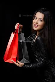 Specialty stationary or fine writing pens. A Young Woman In A Black Dress Is Happy With A Gift Shopping In Black And Red Bags On A Black Isolated Background People Indivstock