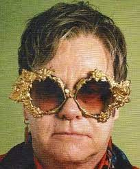 Wearing his signature sunglasses, elton beamed surrounded by his friends as alice mimed. Elton John Is The Ultimate Pop Style Icon Elton John Sunglasses Elton John Glasses Elton John