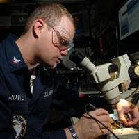 Electronics Technician 3rd Class Chris Elmendorf tests the connectivity of  a circuit board in the micro/miniature repair room.