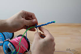 Then, hold the centers in place while you grab one end of the bottom strand and draw it up over the center to make a large loop. Bring Back The 90s With A Party Lanyard Station Between Carpools