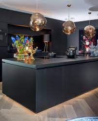 matzwart kookeiland met ronde lampen van goud glas en fleurige woonaccessoires keuken in woonkamer keuken keuken ontwerp